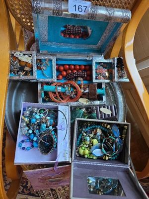 a lot of jewelry in a box on a chair