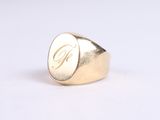 the gold signet ring with the letter g on it