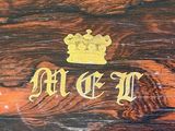 a close up of a wooden box with a crown on it