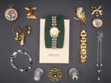 an assortment of gold and silver jewelry including a watch, bracelets, broochet, and other items