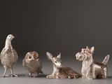 three silver figurines of animals and a bird sitting next to each other