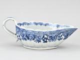 a blue and white bowl with a handle on a white surface