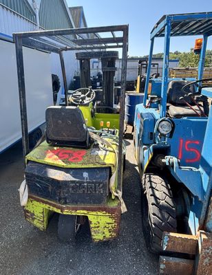 deux chariots élévateurs garés devant un bâtiment
