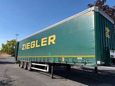 une semi-remorque verte garée sur le bord de la route