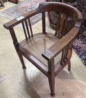 FAUTEUIL de forme gondole en chêne, assise cannée.