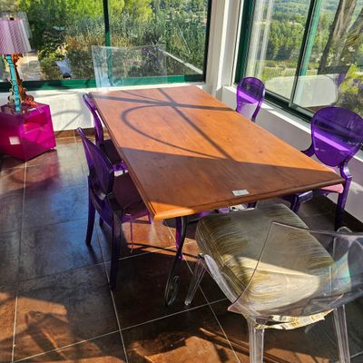 une table et des chaises dans une pièce avec une grande fenêtre