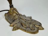a gold colored lamp that is on a white table