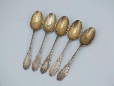 six silver spoons sitting on top of a white surface