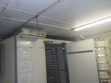 une photo d'un réfrigérateur dans une pièce comportant de nombreuses étagères