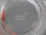 a close up of a glass vase with a red flower on it