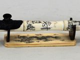 un petit objet blanc et noir posé sur un socle en bois
