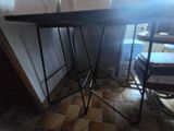 a picture of a table with two stools in a room