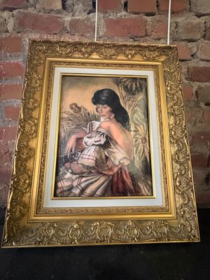 un tableau représentant une femme tenant un bébé dans ses bras, dans un cadre doré