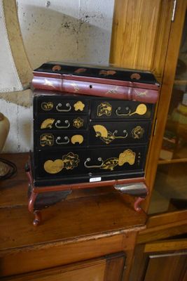 a black and gold chest on top of a wooden cabinet