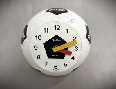 a white clock with a yellow and red arrow on it