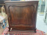 an old wooden cabinet sitting on top of a rug in a room