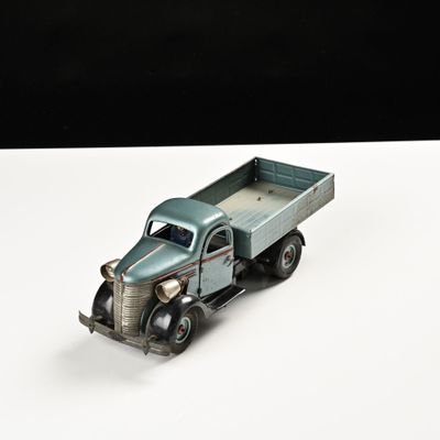 un camion jouet posé sur une surface blanche
