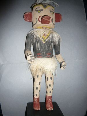 un jouet en bois représentant un clown, posé sur un socle noir
