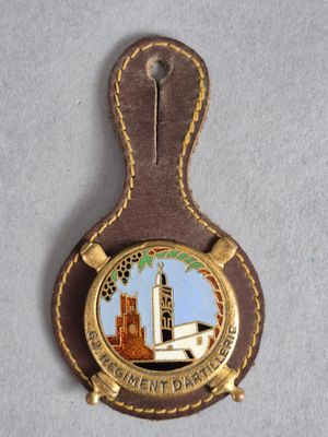 un gros plan sur un badge accroché à un porte-clés en cuir marron