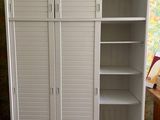a white cabinet with shelves in the corner of a room