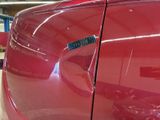 a close up of a red car with a sticker on it
