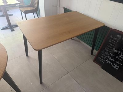 a wooden table with a blackboard on the wall
