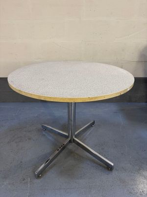 une table blanche avec un plateau en bois posée sur un sol en béton