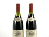 deux bouteilles de vin posées l'une à côté de l'autre sur une surface blanche
