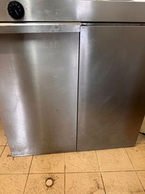 a stainless steel dishwasher sitting on a tiled floor