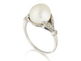 gros plan d'une bague en perles et diamants sur fond blanc
