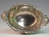 an antique silver plate with a decorative design on the rim