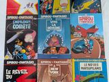 une pile de bandes dessinées est alignée sur une surface blanche