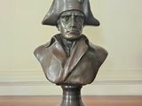statue of a bust of a man wearing a hat on a wooden table