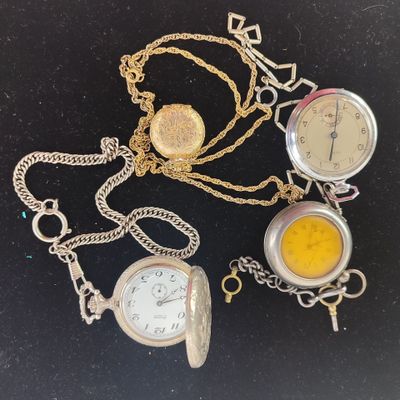 three different types of pocket watches on a black surface