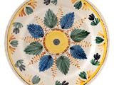 a yellow and blue plate with leaves on it