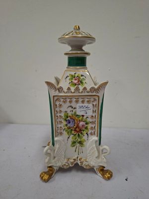 a green and white vase with flowers on it