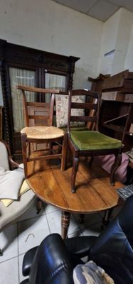 plusieurs chaises et une table dans une pièce avec beaucoup de meubles