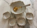 a bowl with a spoon in it and six small bowls in it