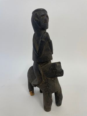 an old wooden statue of a woman sitting on a horse