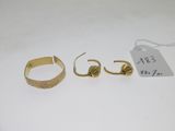 trois bagues en or et une bague sur laquelle est accrochée une étiquette de prix