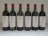 six bouteilles de vin sont alignées sur une table