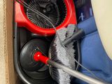 a cardboard box filled with cleaning supplies and a fan