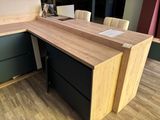 a wooden desk with a black drawer underneath it