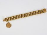 a close up of a gold bracelet with a medallion on it