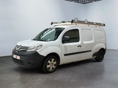 La camionnette blanche est garée dans une grande pièce, avec une échelle sur le toit.