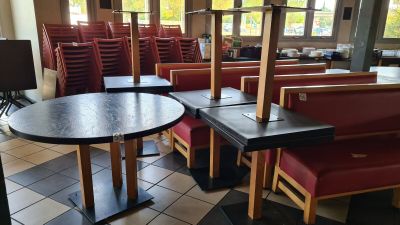 tables and chairs in a restaurant with a television in the background