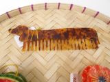 a brown dog shaped comb sitting on top of a table