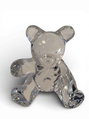 un ours en peluche en verre posé sur une surface blanche