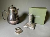 a silver tea pot and a silver teapot next to a green box