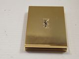 an image of a gold compact case with a monogram on the front